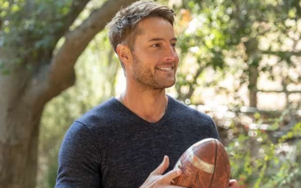 Justin Hartley segura uma bola de futebol americano em cena da quinta temporada de This is Us