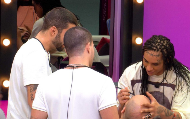 Arthur Aguiar e Pedro Scooby observam Linn da Quebrada maquiar Tiago Abravanel no BBB 22