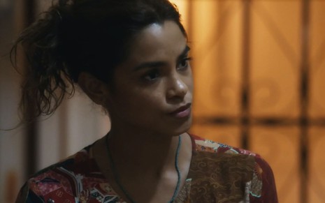 A atriz Lucy Alves como Brisa em Travessia; ela está de lado, olhando para o lado com cara de emburrada