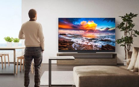 Telespectador admira imagens de uma TV 8K em sala decorada