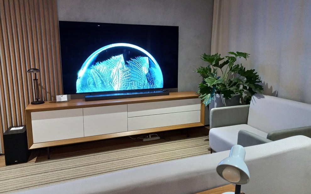Sala com decoração moderna e televisor apoiado sobre o móvel