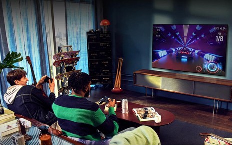 Jovens jogando videogame em TV de tecnologia OLED