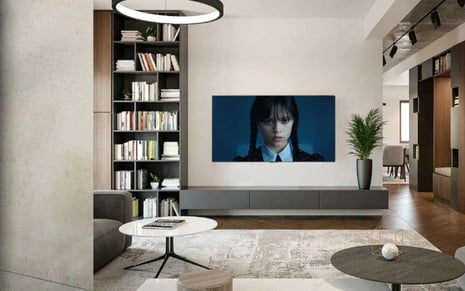 TV instalada em ambiente decorado exibe a série Wandinha, da Netflix