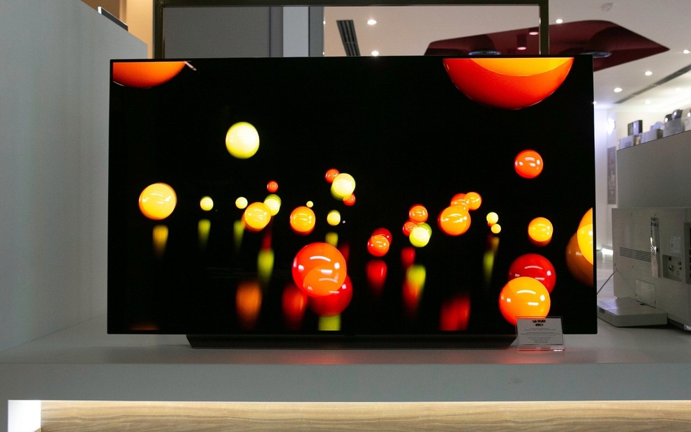 TV OLED exposta em uma loja exibe bolhas coloridas em um fundo escuro