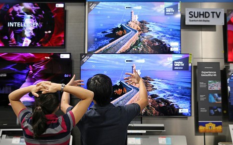 Consumidores escolhendo TV de tela grande na loja