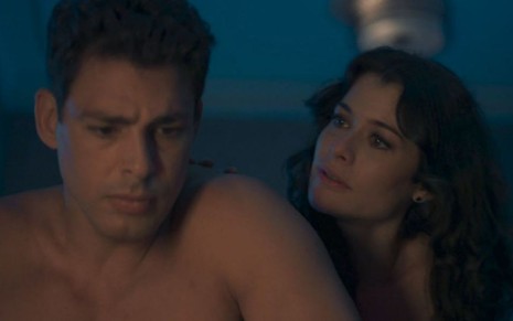 Bárbara (Alinne Moraes) sentada na cama ao lado de Christian (Cauã Reymond) em cena de Um Lugar ao Sol
