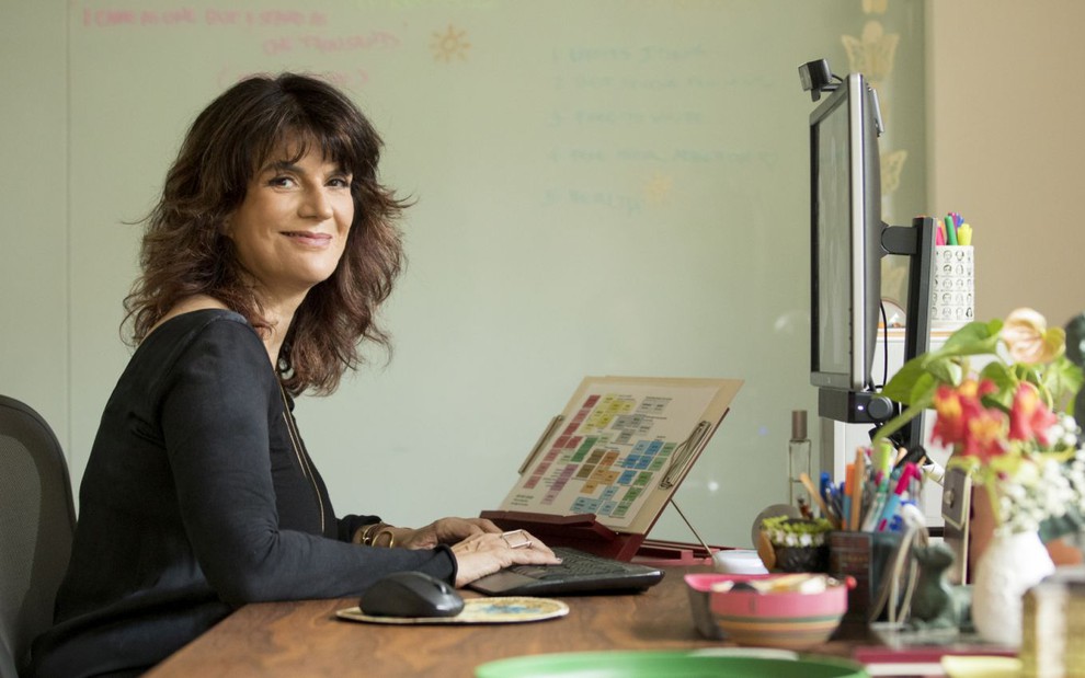 Autora de Um Lugar ao Sol, Lícia Manzo está trabalhando  em um computador em seu escritório