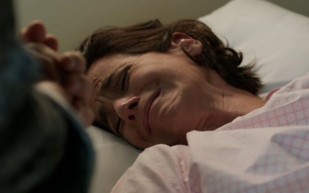 A atriz Mariana Lima chora deitada em leito de hospital como a personagem Ilana em cena de Um Lugar ao Sol