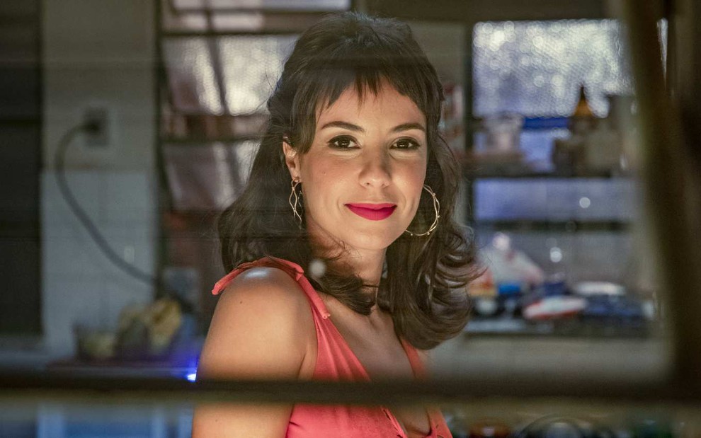 A atriz Andréia Horta posa para a câmera e sorri no cenário de Um Lugar ao Sol