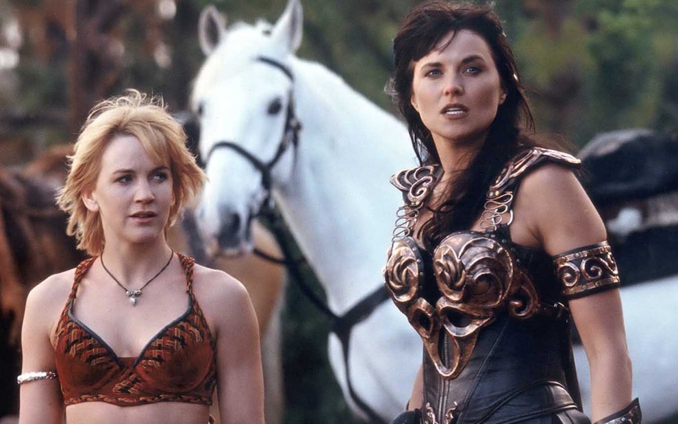 A atriz Renée O'Connor como Gabriele à esquerda, seguida por um cavalo branco e então Lucy Lawless como Xena em cena de Xena: A Princesa Guerreira