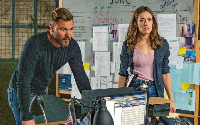 Patrick John Flueger e Marina Squerciati se apoiam em mesa durante cena de Chicago P.D.
