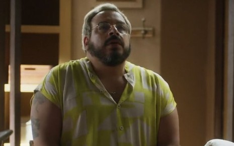 Em cena de Vai na Fé, Luis Lobiando está usando blusa amarela e branca e está com a expressão de medo