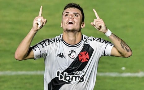 Gabriel Pec, do Vasco, veste uniforme branco com faixa diagonal preta e comemora gol com mãos pra cima