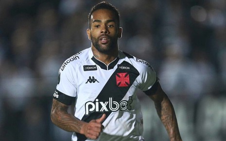 Alex Teixeira, do Vasco, corre em campo e veste uniforme branco com faixa diagonal preta