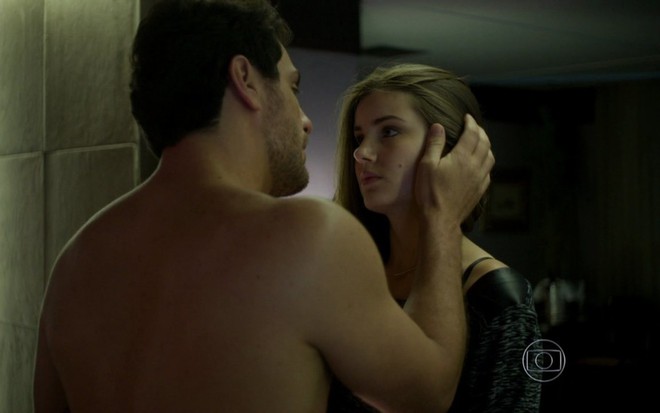 O ator Rodrigo Lombardi, sem camisa, aparece de costas, com mão no rosto da atriz Camila Queiroz, que parece assustada, em cena de Verdades Secretas