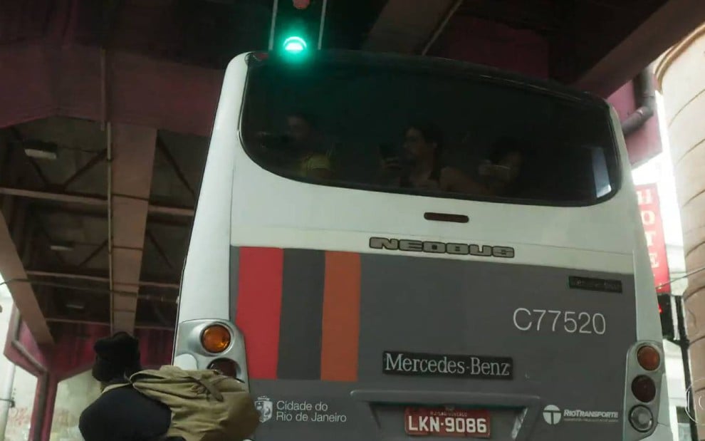 Ator Matheus Abreu surge ao lado de ônibus sob viaduto em cena de Quanto Mais Vida, Melhor