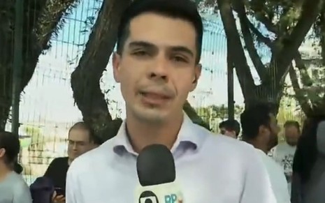 O repórter Murilo Souza segura um microfone com o logo da Globo e da RPC