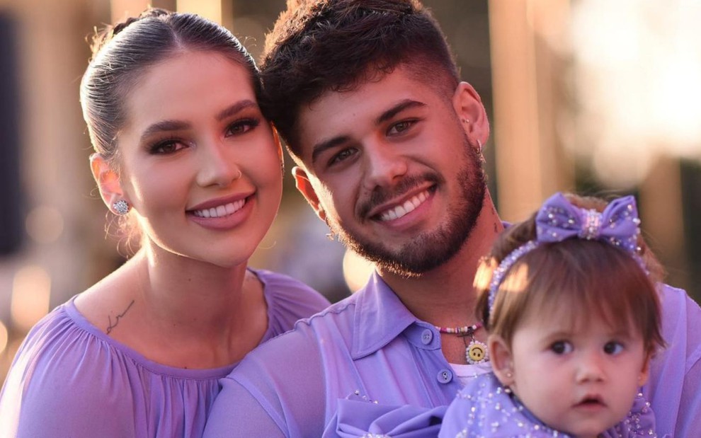 Virgínia Fonseca, Zé Felipe e Maria Alice posam para foto, os adultos sorrindo, todos de roupas lilás