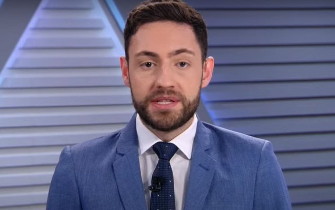 Vitor Brown usa terno e está no cenário do programa Os Pingos nos Is