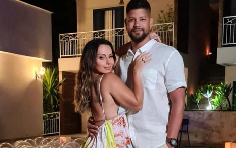 Viviane Araújo usa vestido florido e o marido, Guilherme Militão, usa uma camisa branca e uma calça de sarja bege