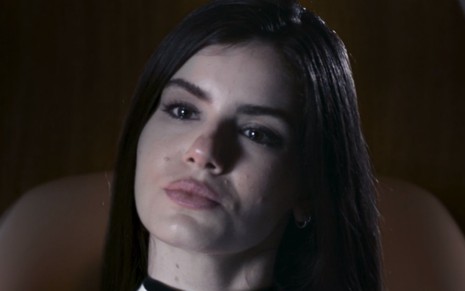 Atriz Camila Queiroz olha para frente com cara de séria em cena de Verdades Secretas 2