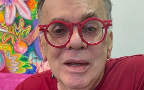 O autor de novelas Walcyr Carrasco. Ele está usando um par de óculos vermelhos e olhando para frente enquanto conversa
