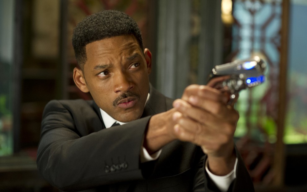 Will Smith segurando uma arma em cena de Homens de Preto 3