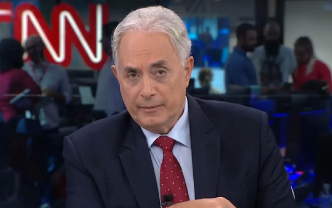 William Waack na CNN Brasil com um terno preto e uma gravata vermelha