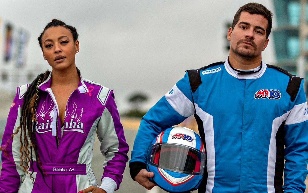 Sheron Menezzes e Thiago Martins com uniformes de pilotos de Fórmula Truck em filme da Netflix, posam para foto de frente