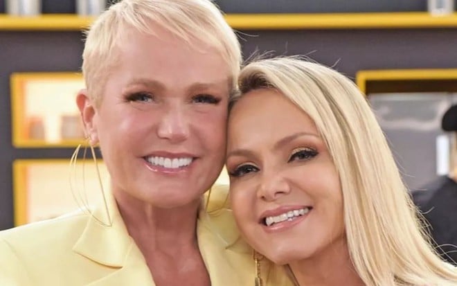 Xuxa e Eliana lado a lado, sorrindo para foto em estúdio do SBT