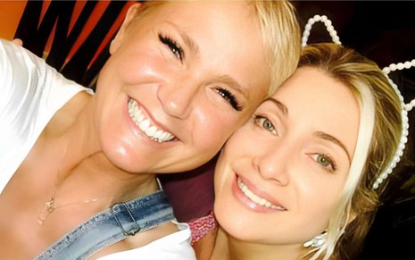 Xuxa e Letícia Spiller com os rostos colados enquanto sorriem