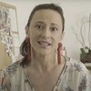 Paula Braun em vídeo publicado no YouTube: atriz está com brincos vermelhos, bata branca e cabelo preso de lado