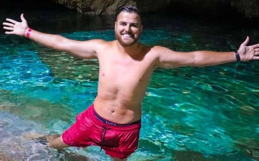 Zé Neto posa para foto com braços abertos em um lago dentro de uma caverna no México