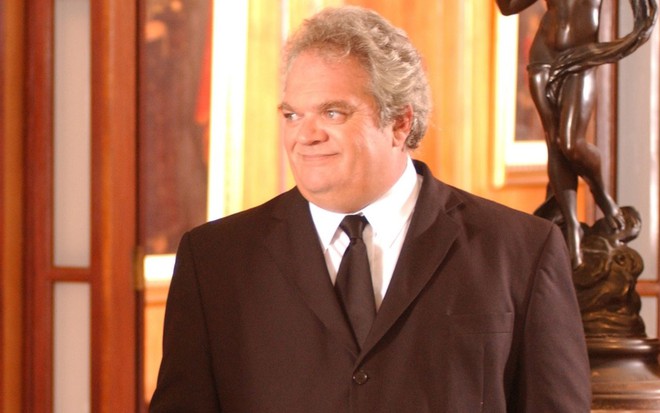 José Victor Castiel sorri e usa terno em cena da novela Páginas da Vida