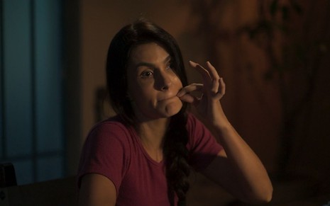 A atriz Paula Barbosa como Zefa em Pantanal; ela está gesticulando com a mão na direção da boca para simular que passou um zíper em cena novela da Globo