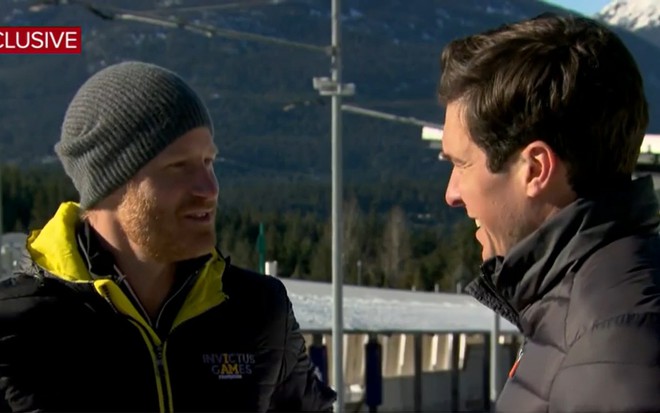 Com roupas de frio em uma estância nevada, o príncipe Harry conversa com o jornalista Will Reeve