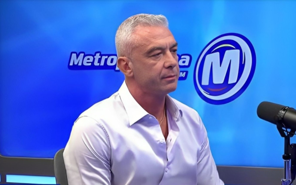 Alexandre Correa, marido de Ana Hickmann, em entrevista à rádio Metropolitana em que negou agressão; ele veste camisa branca e está à frente do logotipo da rádio