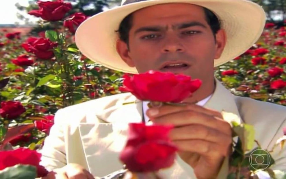 O ator Eduardo Moscovis segurando uma rosa vermelha em cena de Alma Gêmea