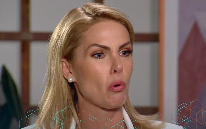 Ana Hickmann, usando um conjunto branco, dá entrevista para Carolina Ferraz em estúdio da Record, na última quinta-feira, 23