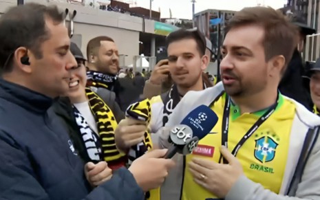 O repórter André Galvão entrevistando torcedores na porta do estádio de Wembley, em Londres