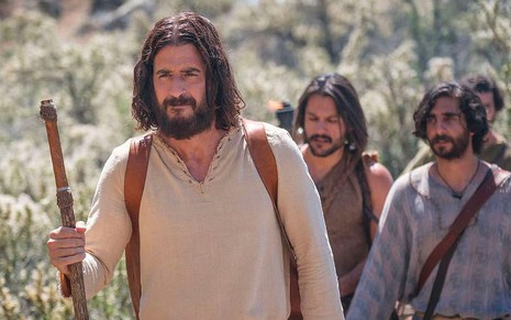 Caracterizado como Jesus, o ator Jonathan Roumie caminha com o apoio de um cajado de madeira