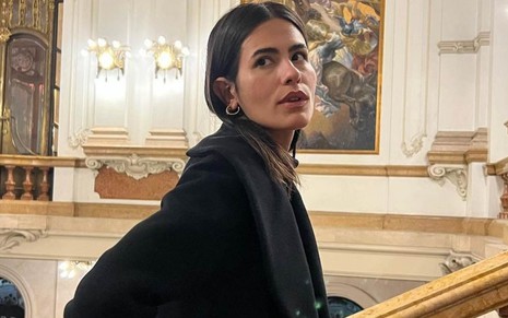 Antonia Morais em foto publicada no Instagram, com casaco preto, olhando séria para a esquerda