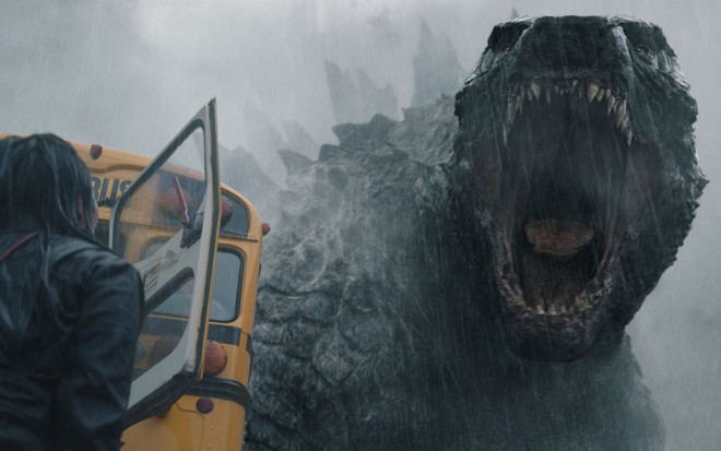 Mulher de costas olha para o alto, enquanto Godzilla 'ruge' de boca aberta em cena de Monarch: Legado de Monstros