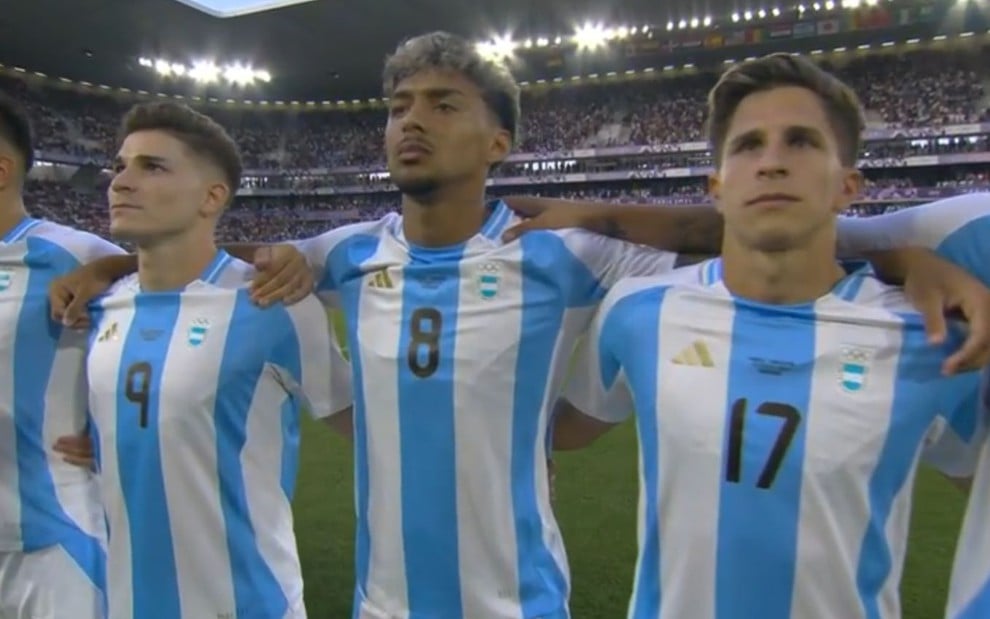 Três jogadores Argentinos abraçados durante a execução do hino nacional na Olimpíada de Prais