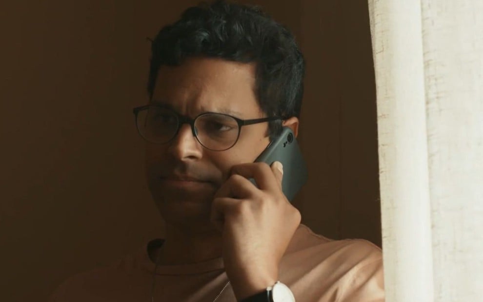 Em cena de Renascer, Renan Monteiro está falando ao celular com a expressão de preocupação