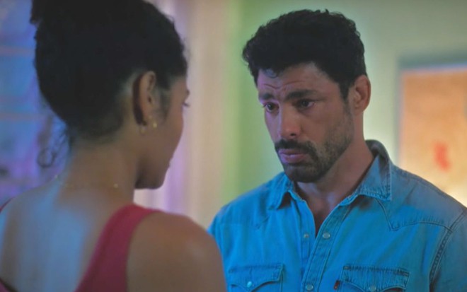 De costas na imagem, Aline (Barbara Reis) conversa com Caio (Cauã Reymond) em cena da novela Terra e Paixão