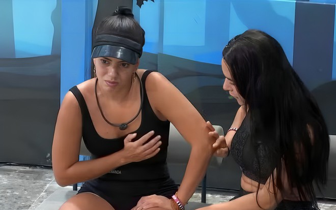 Fernanda Bande faz careta de dor e leva a mão ao peito no BBB 24, enquanto Isabelle Nogueira a conforta