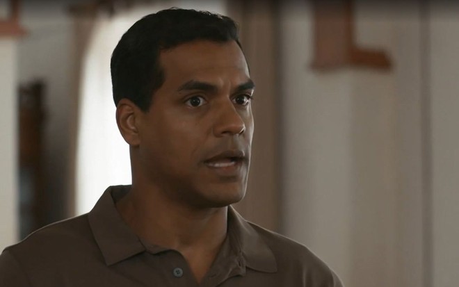 Em cena de Renascer, Marcello Melo Jr está falando com alguém, com a expressão séria