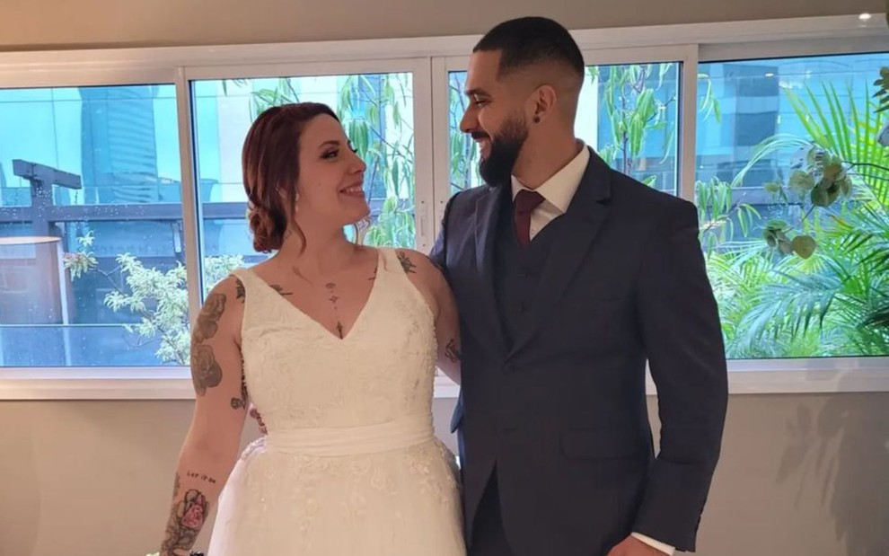 Bianca Sessa e Jarbas Andrade se olham e estão com roupas de casamento