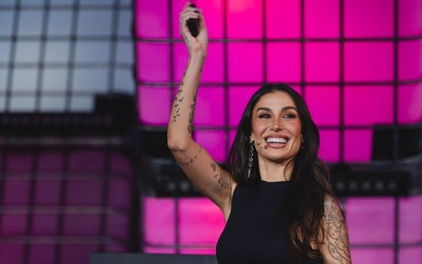 A influenciadora e empresária Bianca Andrade durante palestra de 20 minutos na Web Summit Rio; ela está sorridente e segurando microfone